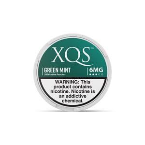 Green Mint Nicotine Pouches by XQS in a resealable pouch with fresh mint leaves and green packaging.